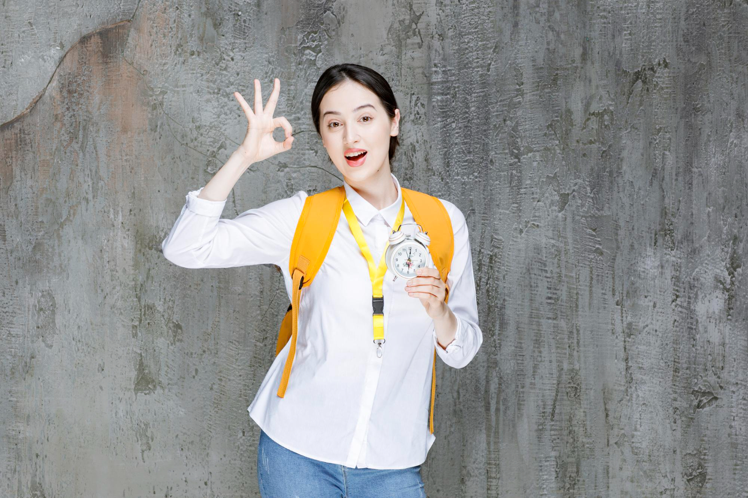 Female student with backpack holds a clock